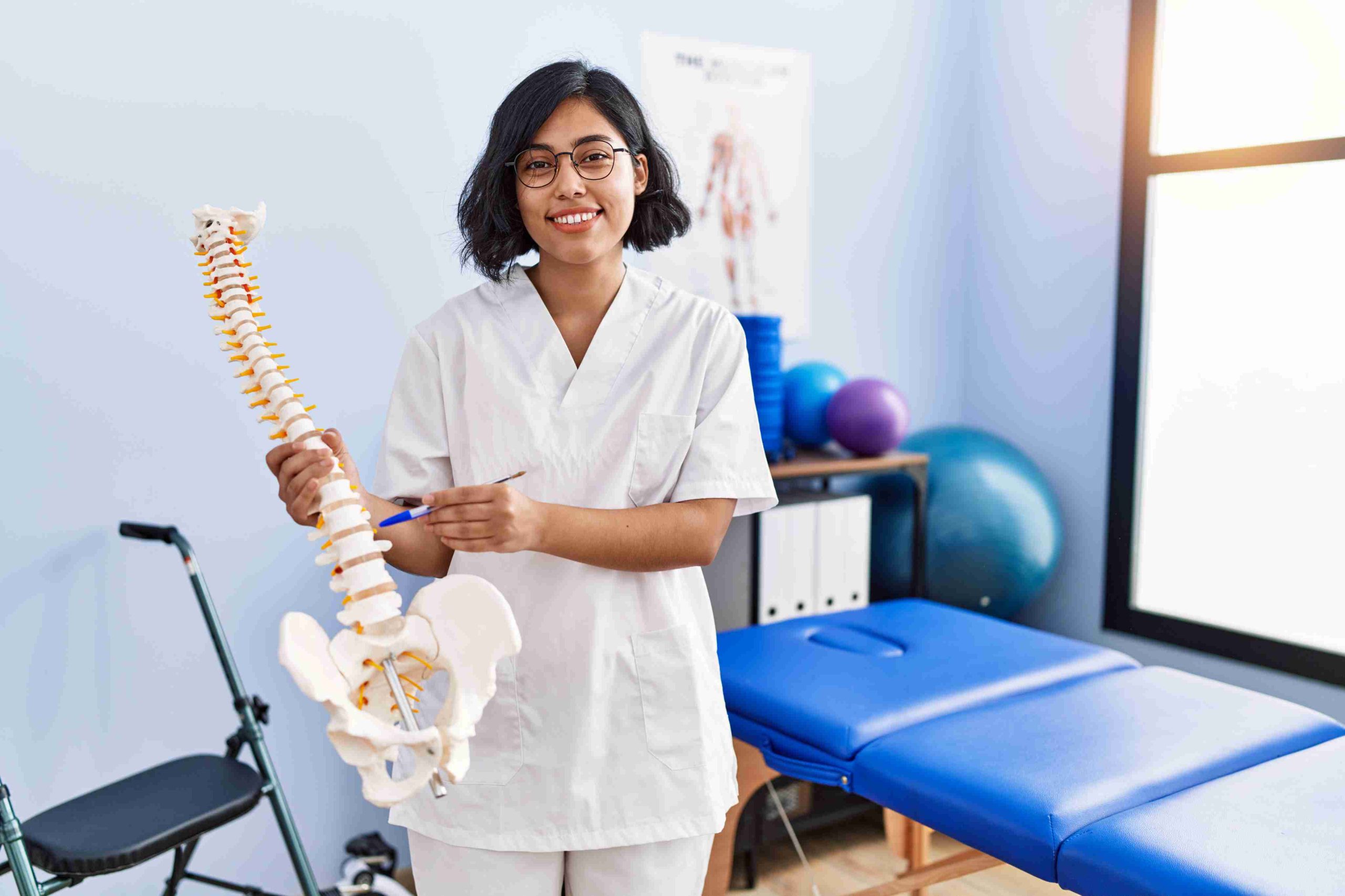 Physiotherapist discussing spinal health with anatomical model at Enspire Calgary